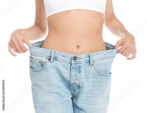 Slim young woman with smooth gentle skin in oversized jeans on white background, closeup. Beauty and body care concept