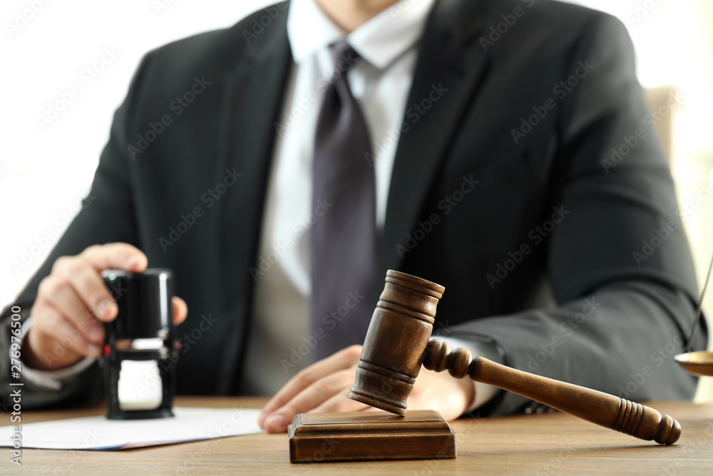 Gavel and blurred view of notary on background Gavel and blurred view of notary on background