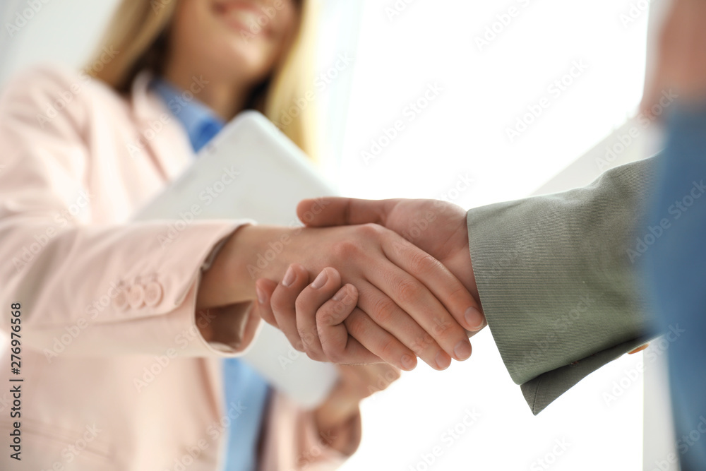 Business partners shaking hands after meeting, closeup