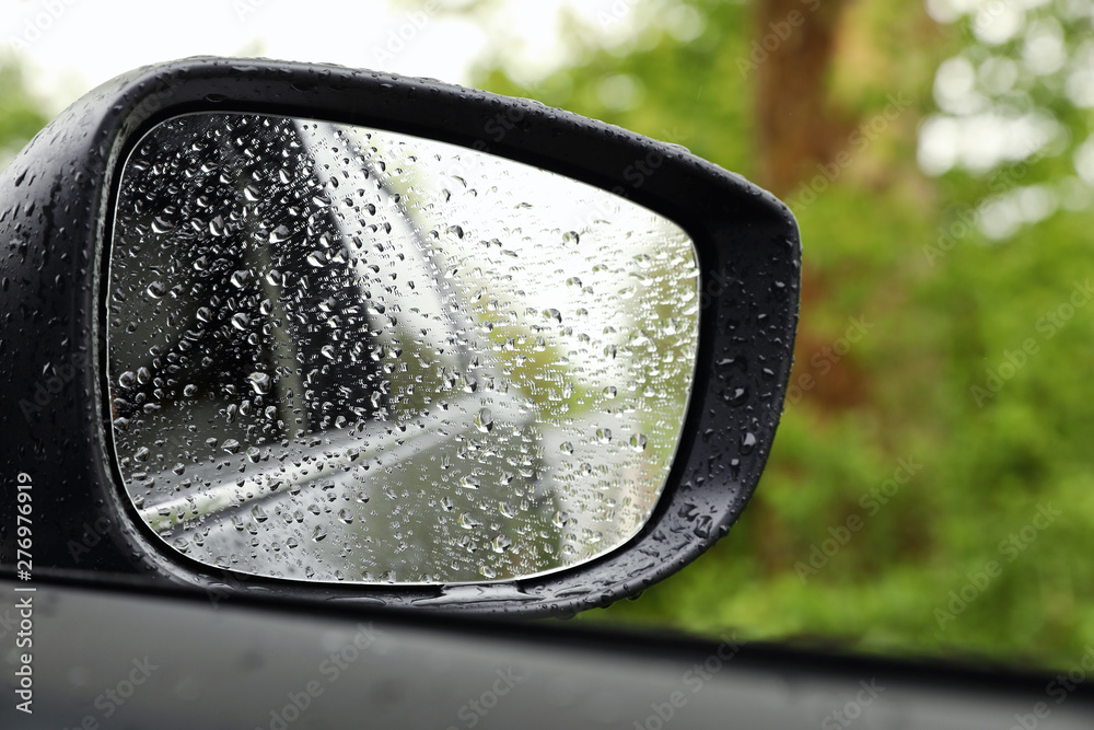 Closeup of car side rear view mirror with rain drops Closeup of car side rear view mirror with rain drops