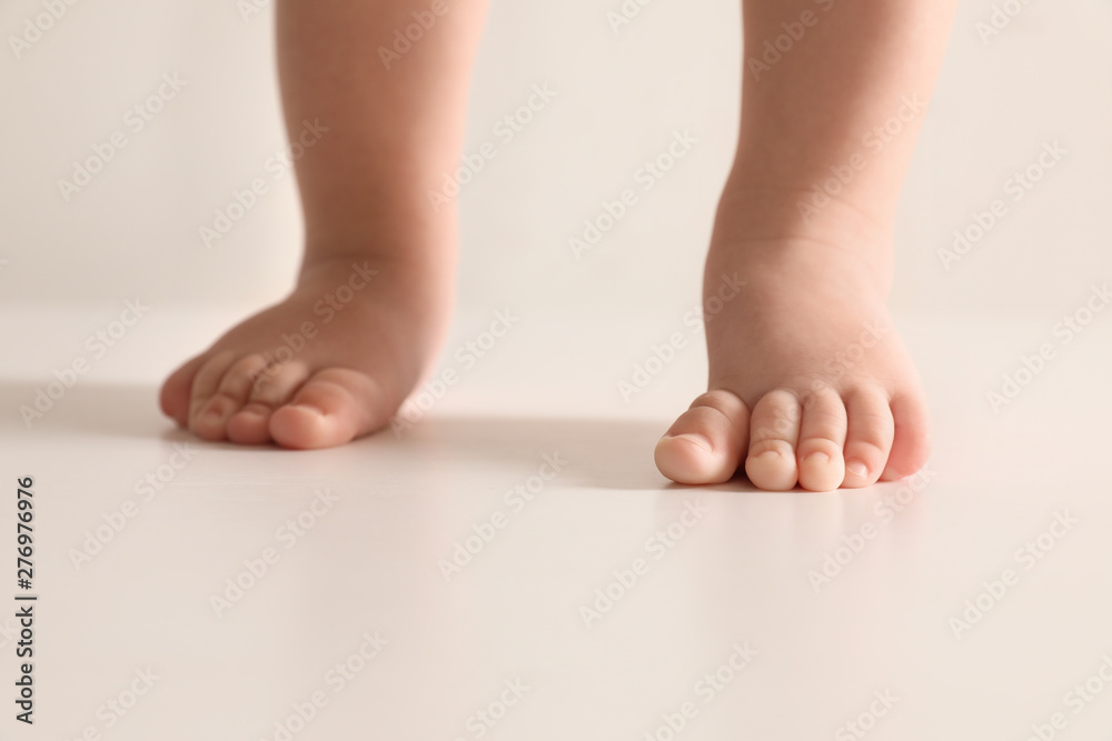 Little baby on light background, closeup on feet