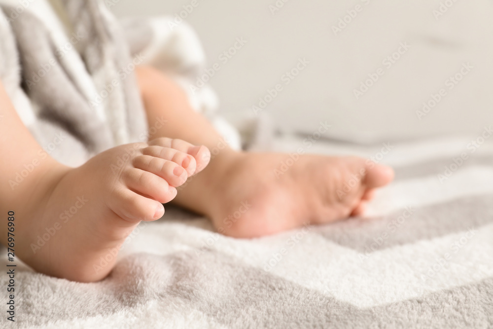 Little baby with cute feet on bed against light background, closeup. Space for text Little baby with cute feet on bed against light background, closeup. Space for text