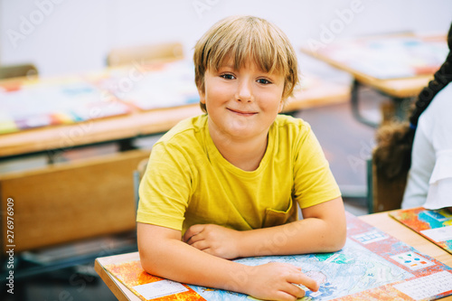 Indoor close up portrait of a cute little boy in a classroom