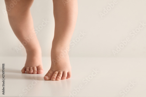 Little baby on light background, closeup on feet. Space for text