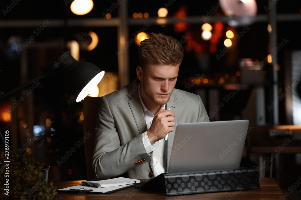 Young man working in office at night Young man working in office at night
