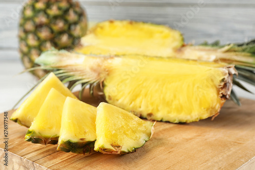 Cut fresh juicy pineapple on wooden board, closeup