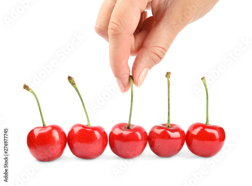 Woman holding ripe sweet cherry on white background, closeup