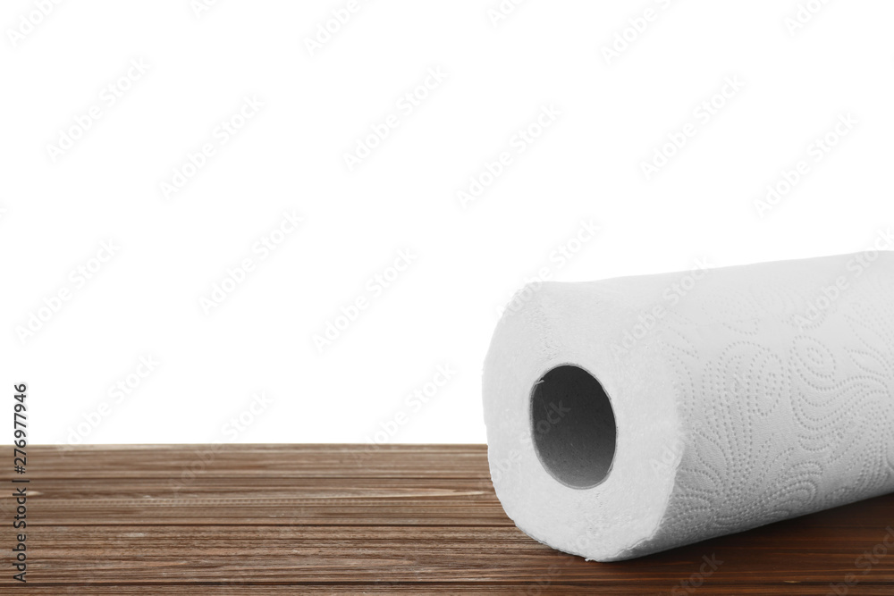 Fototapeta premium Roll of paper towels on wooden table against white background, space for text