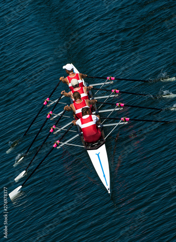 Картината върху платно Four Male Rowers In A Quad Racing Boat With Synchronous Oar Stroke
