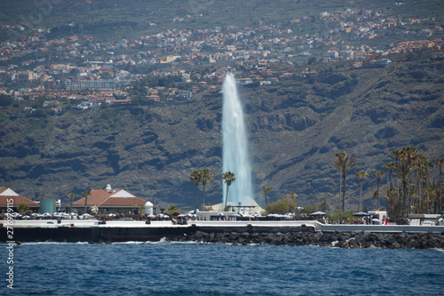 Puerto de la Cruz, Tenerife - April 12, 2017: view of the townscape and the coastline on a sunny day. Fountains of Lago Martianez - famous place for tourists and local people. Long focus lens shot