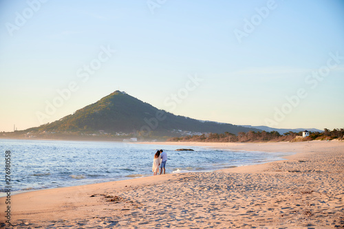 Woman in a white dress on the beach at Moledo, Portugal. With a mountain in background photo