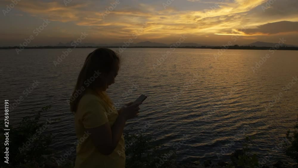 Women with happy using a smart phone. During the time of sunset. Women with happy using a smart phone. During the time of sunset.