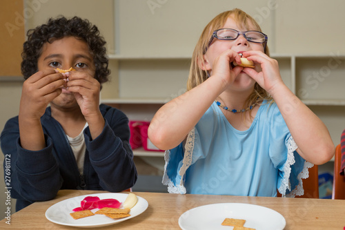 Young Interracial Kids At School Having Fun And Eating Crackers And Cheese Together