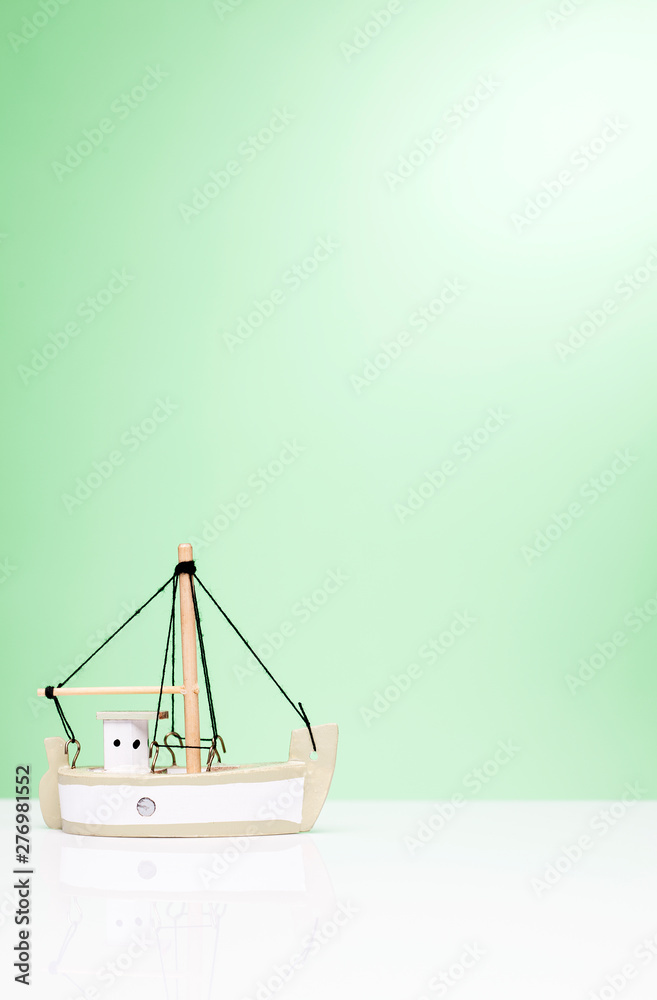Miniature sailboat on a green background. Miniature sailboat on a green background.