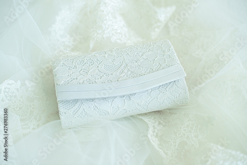 White brides clutch purse on brides wedding dress