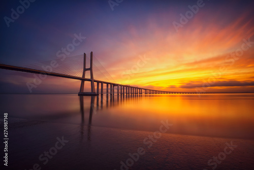 Fototapeta Naklejka Na Ścianę i Meble -  Colorido amanecer con el puente Vasco da Gama al fondo, Lisboa, Portugal.