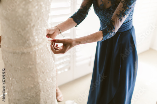 brides mother helping bride with dress