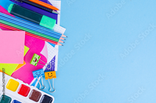 Back to school with schools accessories - paints, pencils, notebooks, scissors, markers, blue background.  © ArtCookStudio