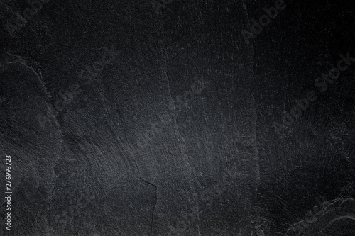Dark grey black slate background or natural black stone texture.