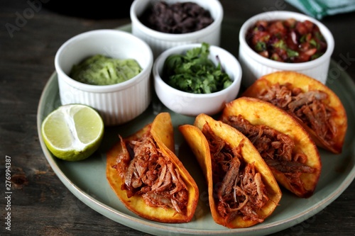 tacos with pork long languor and different sauces, salsa, guacamole, ketchup, cilantro. fried tortilla cakes