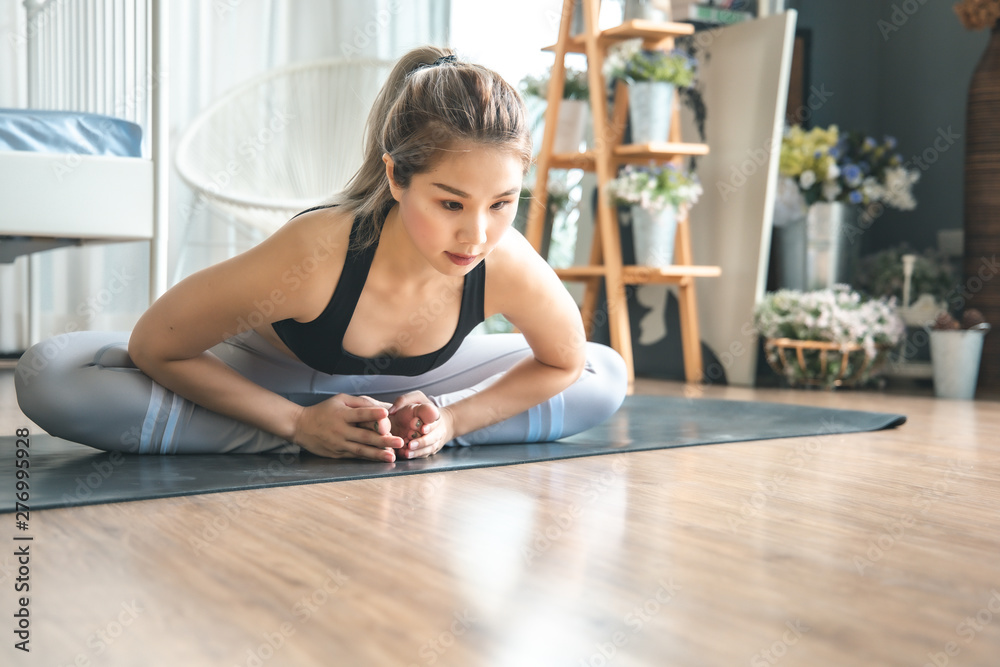 Young woman practicing yoga in gray background.Young people do yoga indoor at home. Young woman practicing yoga in gray background.Young people do yoga indoor at home.
