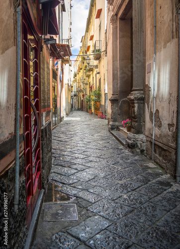Charming, empty, narrow, cobbled street lined with old, stone buildings in Italy © ShannonK