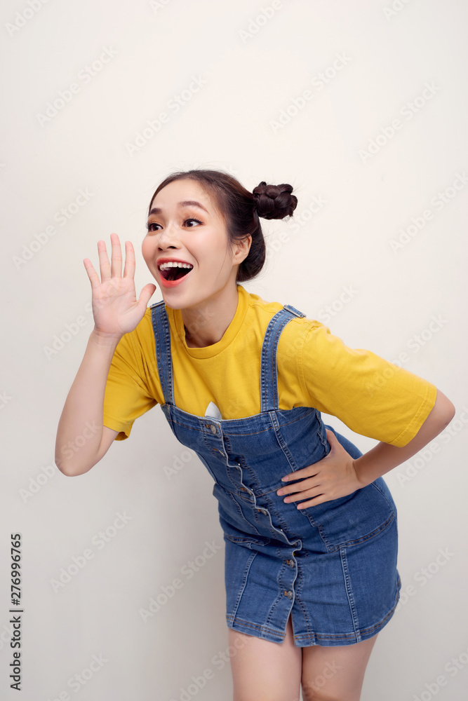 Portrait of pretty joyful woman with two buns holding hands at face and calling aside isolated over white background Portrait of pretty joyful woman with two buns holding hands at face and calling aside isolated over white background