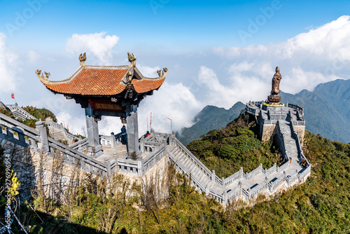 SAPA, VIETNAM - MAR 14, 2019 Statue of the Guan-Yin Buddha and Pavilion on Fansipan mountain peak the highest mountain in Indochina Backdrop Beautiful view blue sky and cloud.