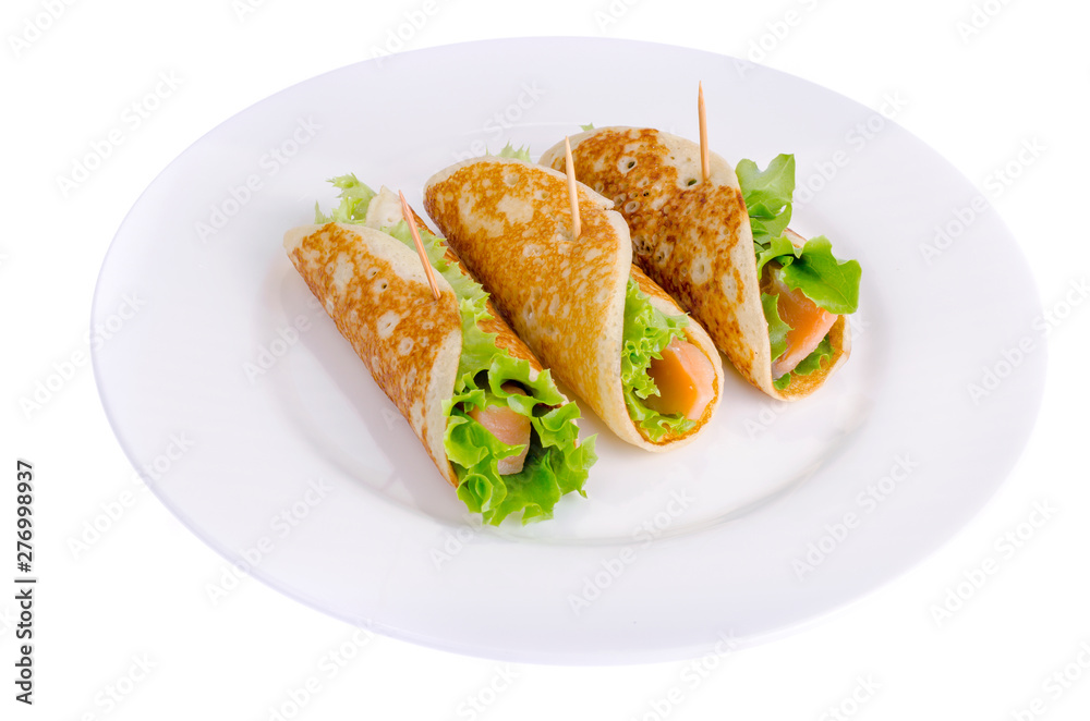 Snack rolls from pancakes, salmon and green salad leaves. 