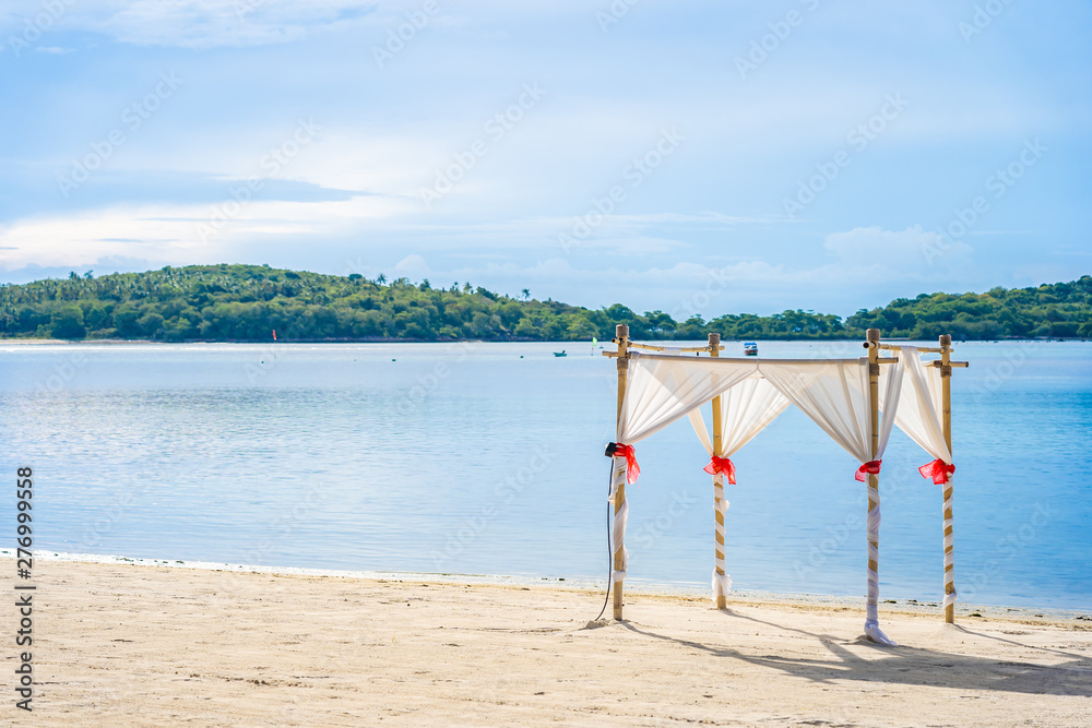 Beautiful outdoor tropical beach sea ocean with umbrella chair and lounge deck around there on white cloud blue sky Beautiful outdoor tropical beach sea ocean with umbrella chair and lounge deck around there on white cloud blue sky