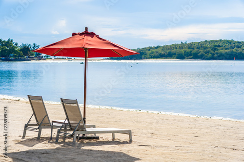 Beautiful outdoor tropical beach sea ocean with umbrella chair and lounge deck around there on white cloud blue sky