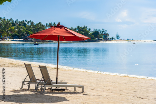 Beautiful outdoor tropical beach sea ocean with umbrella chair and lounge deck around there on white cloud blue sky