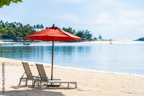 Beautiful outdoor tropical beach sea ocean with umbrella chair and lounge deck around there on white cloud blue sky