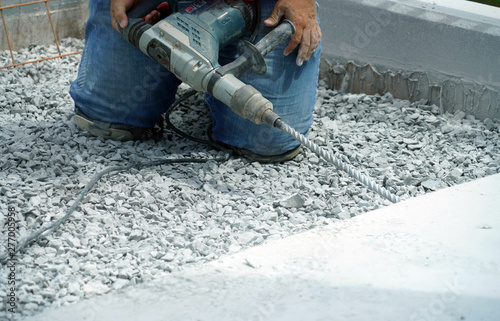 Wallpaper Mural manual worker operating drill to repair the road Torontodigital.ca