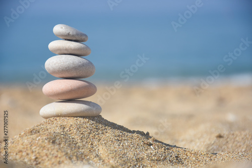 Balanced stone pyramid on sand on beach. Zen rock  concept of balance and harmony