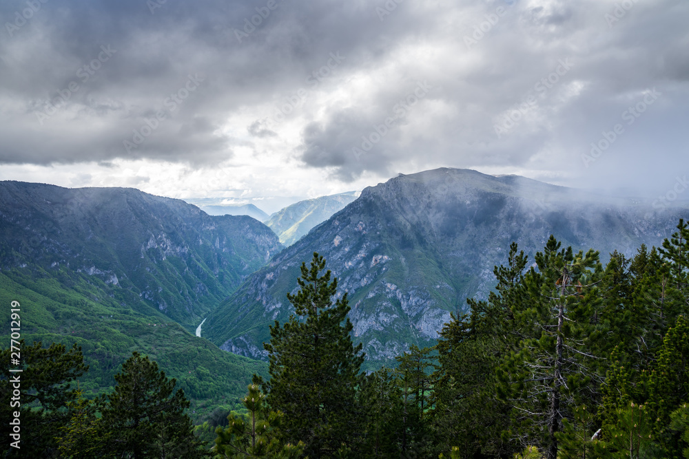 Montenegro, Spectacular view over tara river canyon with dramatic sky of rain clouds and sun from mountain curevac in durmitor national park nature landscape of zabljak