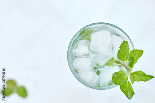 Summer hot fresh drink with mint in glass on white green grey background