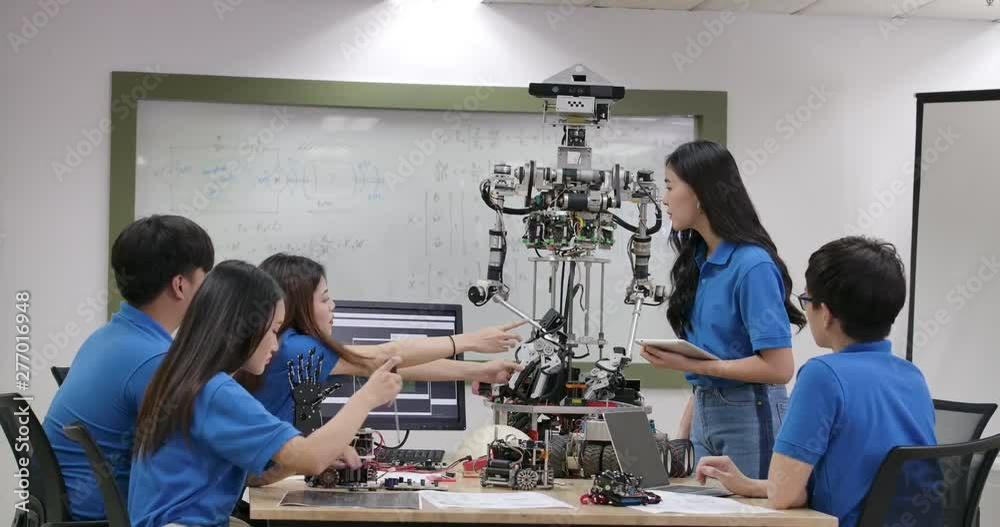 Young electronics engineer team collaborating on construction of robot in the workshop. Team engineer start up for robot project together. People with technology or innovation concept.