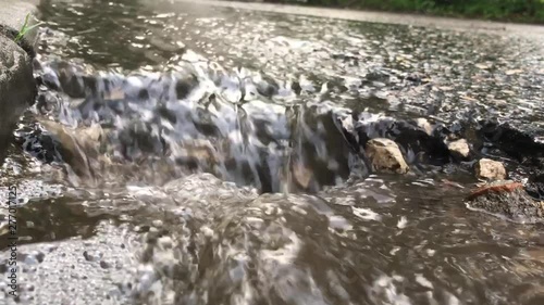 water after rain. stream in the city. rainwater flows along the road. small waterfall