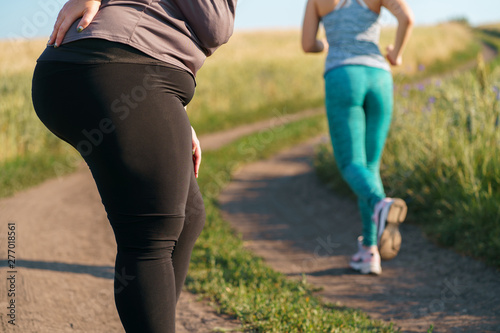 Woman suffering from back ache at outdoor workout. Overweight harm for spine. Health care concept