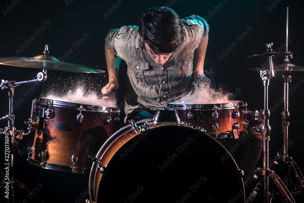 musician playing drums with splashes, black background with beautiful soft light musician playing drums with splashes, black background with beautiful soft light