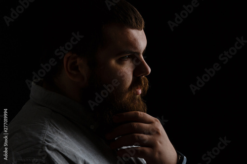 Serious fashionable man with beard&mustache in suit. Men's beauty, fashion. Fashion portrait of hipster man.with beard touching his mustache.