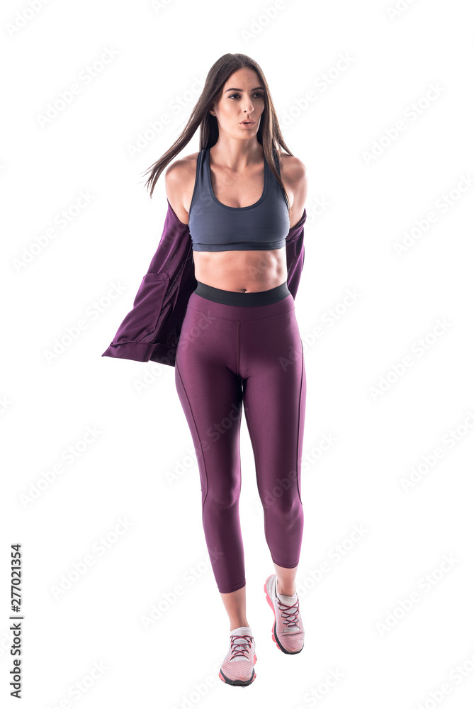 Determinate young athletic woman removing tracksuit jacket getting ready for exercise. Full body isolated on white background. Determinate young athletic woman removing tracksuit jacket getting ready for exercise. Full body isolated on white background.