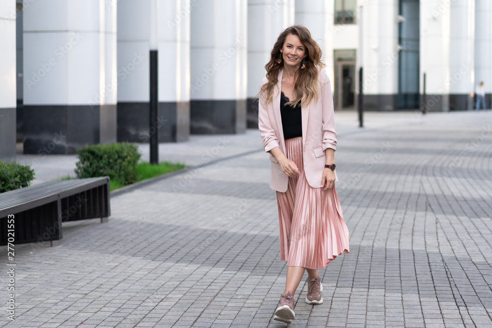 young light-skinned relaxed girl in fashionable clothes walks along the street with a great mood. Lifestyle young light-skinned relaxed girl in fashionable clothes walks along the street with a great mood. Lifestyle
