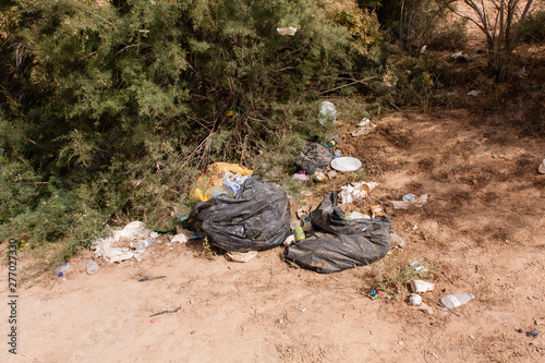 Garbage left by visitors on the shore of the Naquibs Pond near Riyadh