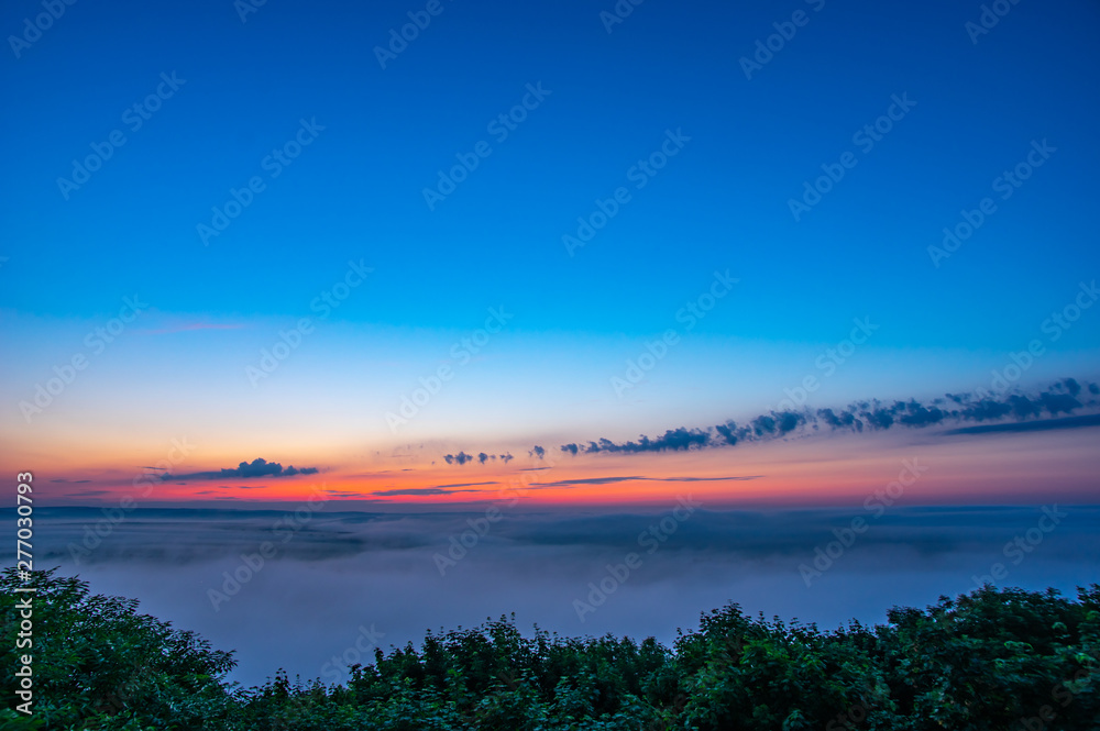 Dawn on a misty morning on a mountain above the river