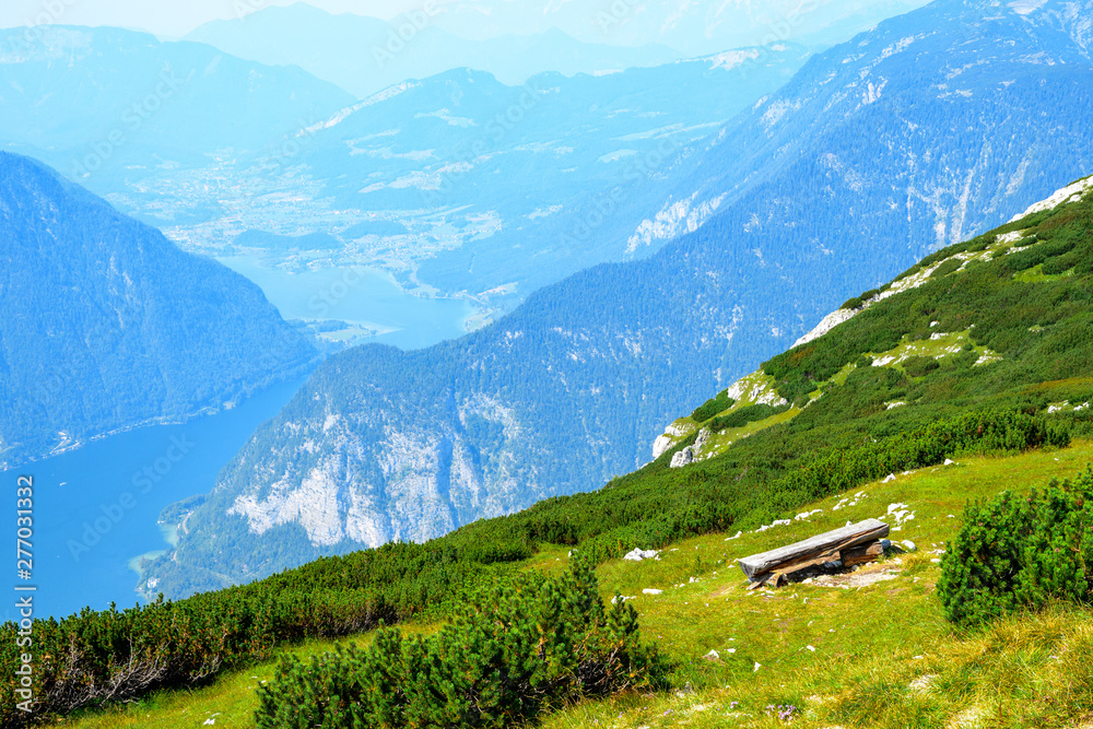 Bench on the slope of a high mountain in the Austrian Alps overlooking the mountain peaks and lake Hallstattersee