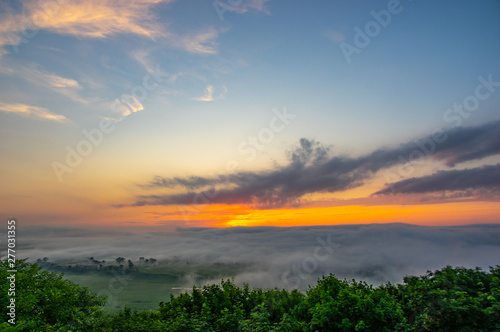 Dawn on a misty morning on a mountain above the river