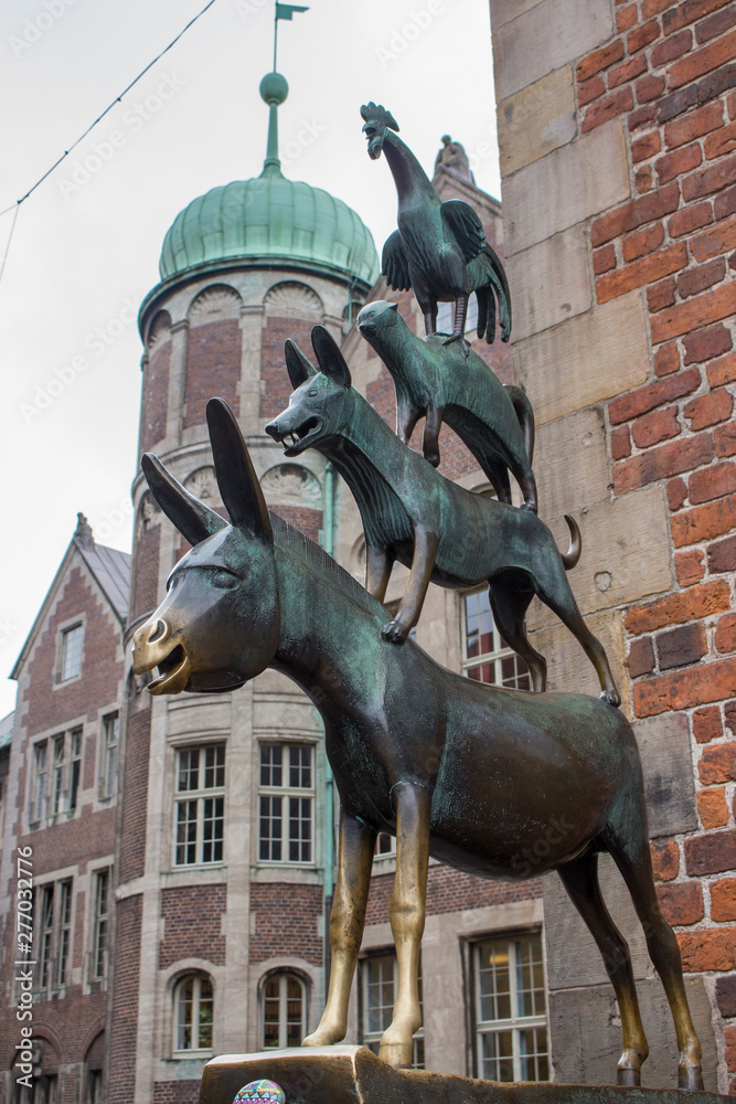 Naklejka premium Bremen, Germany - 06/13/2019: famous sculpture of Bremen musicians. Bronze monument of fairytale animals. Heritage of Grimm brothers. Fairytales concept. Bremen sightseeing. Bremen landmark.