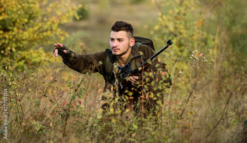 Hunter hold rifle. Hunting is brutal masculine hobby. Hunting and trapping seasons. Bearded serious hunter spend leisure hunting. Man wear camouflage clothes nature background. Hunting permit
